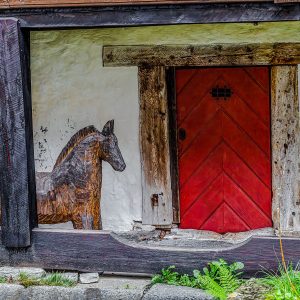 carved-wooden-horse-red-door-agatunet-medieval-farmstead-norway